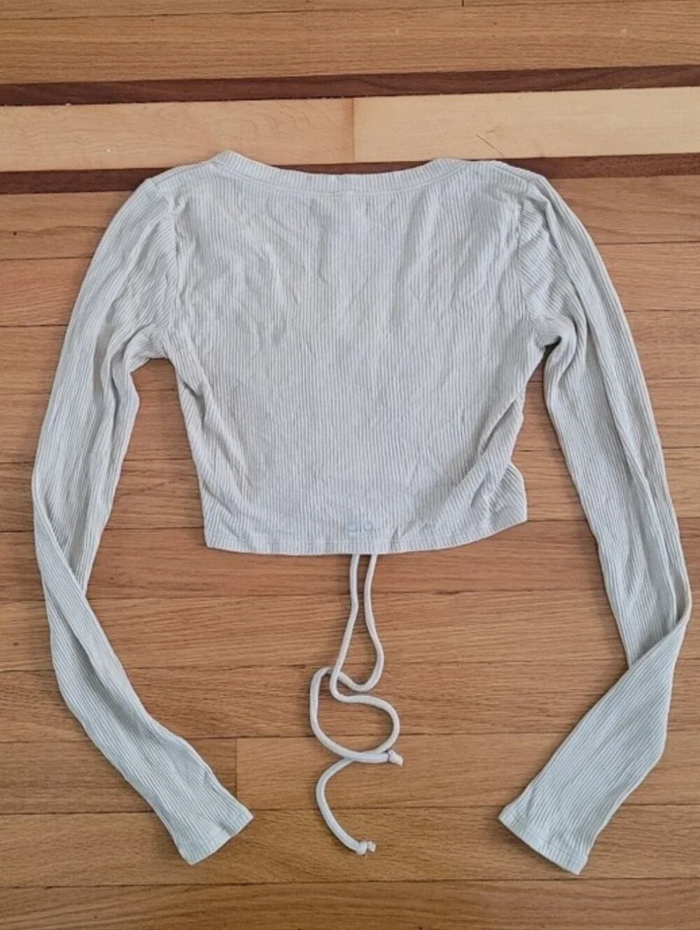 ALO YOGA RIBBED CINCH CROPPED LONG SLEEVE TOP IN CALIFORNIA SAND